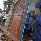 Pam Russell, a la izquierda, rescata a su gato Larue de las ruinas de su casa de Rowlett en Texas, tras el paso de un tornado.