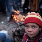 Un ni&ntilde;o trata de calentarse junto a un fuego en el patio de una casa, despu&eacute;s de huir de los combates entre el ISIS y las fuerzas de seguridad iraqu&iacute;es en Tall Kaysumah, al oeste de Mosul, Irak, el 4 de marzo de 2017. Luego,...