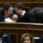 Dos diputados de Podemos, Pablo Iglesias e íñigo Errejón, hacen carantoñas al bebé de su compañera, Carolina Bescansa.