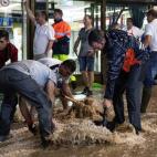 Varias personas tratan de achicar agua tras la tromba en Arganda del Rey