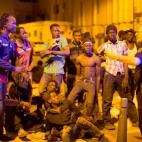 Los migrantes africanos escuchan a un oficial de polic&iacute;a despu&eacute;s de cruzar la frontera.