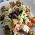 Con pepino, queso feta, tomates, aceitunas y pan tostado. Puedes ver aquí cómo prepararla.