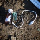 Un bote de medicina, un blíster de pastillas y un cable de carga.