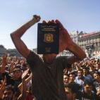 Un inmigrante muestra su pasaporte durante una manifestación, al no dejarlos subirse a los trenes, cerca a la Estación de Trenes Oriental en Budapest (Hungría). Una afluencia de inmigrantes a la Unión Europea presenta desafíos profundos, en...