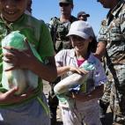 Varios niños refugiados reciben alimentos mientras cruzan la frontera entre Macedonia y Grecia, cerca del pueblo de Gevgelija, Macedonia.