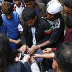 Varios voluntarios donan ropa a los refugiados que esperan frente a la Oficina de Extranjería en Bruselas. Alrededor de 300 demandantes de asilo acuden cada día a la Oficina para normalizar su situación en el país.