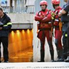 Miembros de los GEAS y bomberos trabajan en la zona donde aún permanece un vehículo que ha quedado atrapado en el paso subterráneo y en el que ha fallecido una persona.