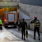 Miembros de los GEAS y bomberos trabajan en la zona donde aún permanece un vehículo que ha quedado atrapado en el paso subterráneo y en el que ha fallecido una persona.