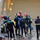 Miembros de los GEAS y bomberos trabajan en la zona donde aún permanece un vehículo que ha quedado atrapado en el paso subterráneo y en el que ha fallecido una persona.