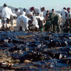 Voluntarios retirando chapapote en la playa de Corrubedo