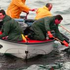 Pescadores retiran el fuel de la superficie en la Ria de Arousa
