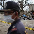 Un policía, en las cercanías del Ayuntamiento de Taclobán, ayuda en las tareas de recuperación e identificación de cadáveres, el 14 de noviembre de 2013.