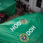 Familias evacuadas y niños del tifón Yolanda reciben las primeras y más básicas ayudas del gobierno y las organizaciones internacionales en Taclobán el 13 de noviembre de 2013.