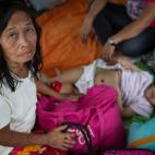 Familias evacuadas y niños del tifón Yolanda reciben las primeras y más básicas ayudas del gobierno y las organizaciones internacionales en Taclobán el 13 de noviembre de 2013.