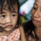 Una madre y una niña filipina, víctimas evacuadas del tifón Yolanda, esperan en las proximidades del aeropuerto de Taclobán el 13 de noviembre de 2013.