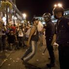 Amenazar, coaccionar, vejar e injuriar a los agentes de las fuerzas de seguridad cuando estén velando por el mantenimiento del orden público, por ejemplo en manifestaciones u otro tipo de protestas. En la fotografía, un manifestante se enfren...
