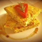 Con huevo, cebolla, patata, bacalao y pimiento del piquillo. Puedes encontrar la receta en Cookpad.