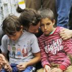 Una mujer consuela a dos niños frente a la casa de Mandela