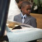 Ronnie Chambers Jr. observa el desconsuelo de su madre, Tahitah Myles, llorando la pérdida de su esposo, Ronnie Chambers, de 33 anni, víctima de la violencia con armas de fuego en Chicago. Foto del 4 de febrero. [El debate sobre las armas en EEUU]