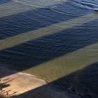 Unos hombres juegan al fútbol en la playa entre las sobras de los edificios de Boa Viagem en Recife, Brasil, el 14 de junio.