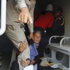 Una anciana agarra la pierna de un policía mientras los residentes de la comunidad del lago Boeung Kak son detenidos durante una protesta en Phnom Penh, Camboya, el 13 marzo de 2013. Los residentes de Boeung Kak Lake protestan por el intento de...