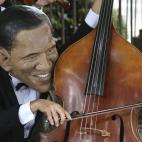 Un activista disfrazado de músico y con una máscara de Obama protesta contra la desigualdad económica en el mundo de cara a la reunión del G-7 en Bruselas, este miércoles.