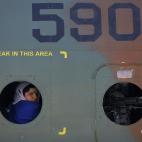 Una mujer afgana se asoma desde una ventana de un helicóptero durante un viaje para celebrar el Día Internacional de la Mujer en el aeropuerto internacional de Kabul, el 7 de marzo 2013.