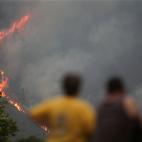 QUIROGA LUGO, SPAIN - JULY 15: Two people watch a fire, on 15 July, 2022 in Quiroga, Lugo, Galicia, Spain. It remains active since 20.29 hours this Thursday a fire in the parish of Outeiro, which according to the latest estimates affects an area...