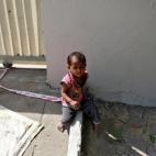 "La ato así para que no salga a la carretera. Mi hijo pequeño tiene tres años y medio y no puede controlarla", revela la madre, Sarta Kalara, una joven de 23 años.