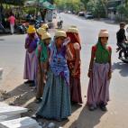 Mientras Shivani espera las horas atada a la piedra, los hombres se acercan para refrescarse con cocos y agua y las mujeres hacen breves escapadas para alimentar a sus hijos.