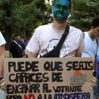 Un joven sostiene una pancarta reivindicativa.
