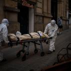 Empleados de una funeraria trasladan el cuerpo de un anciano fallecido por coronavirus en una camilla tras retirarlo de una residencia de mayores, en Barcelona, el 13 de noviembre de 2020.
