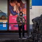 Un joven armado, tras una trinchera hecha de neum&aacute;ticos, en Kiev.