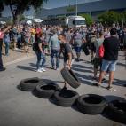 Trabajadores de la planta de Nissan en la Zona Franca de Barcelona concentrados tras conocer el cierre colocan neum&aacute;ticos en un mont&oacute;n.