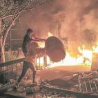 Un grupo de manifestantes participa en la quema de una comisar&iacute;a en Minneapolis.