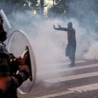A protester tries to talk the police back amid tear gas in downtown Atlanta, Sunday, May 31, 2020. Protests continue across the country over the death of George Floyd, a black man who died after being restrained by Minneapolis police officers on...