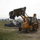 Una excavadora termina de limpiar las tiendas que se han quedado en el campamento de refugiados de Idomeni tras el traslado de los más de 8.000 refugiados que estaban ahí asentados.