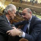 Los ministros en funciones de Defensa, Pedro Morenés, y de Economía, Luis de Guindos, conversan momentos antes de iniciarse la primera jornada de la sesión de investidura del secretario general del PSOE, Pedro Sánchez, en el Congreso de los ...