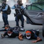 Motorists are ordered to the ground from their vehicle by police during a protest on South Washington Street, Sunday, May 31, 2020, in Minneapolis. Protests continued following the death of George Floyd, who died after being restrained by Minnea...
