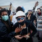 A protester reacts after being hit by crowd dispersal rounds as a group of demonstrators are detained prior to arrest at a gas station on South Washington Street, Sunday, May 31, 2020, in Minneapolis. Protests continued sparked by the death of G...