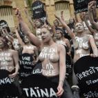 Femen activists hold placards shaped as tombstones, reading the name and the age of each women killed this year by their partner, during a protest action dedicated to the memory of the women killed by their partner or ex-partner and against the ...