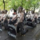 Femen activists hold placards shaped as tombstones, reading the name and the age of each women killed this year by their partner in 2019, during a protest action dedicated to the memory of the women killed by their partner or ex-partner and agai...