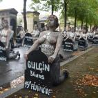 Femen activists hold placards shaped as tombstones, reading the name and the age of each women killed this year by their partner in 2019, during a protest action dedicated to the memory of the women killed by their partner or ex-partner and agai...