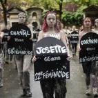 Femen activists hold placards shaped as tombstones, reading the name and the age of each women killed this year by their partner, during a protest action dedicated to the memory of the women killed by their partner or ex-partner and against the ...