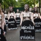 Femen activists hold placards shaped as tombstones, reading the name and the age of each women killed this year by their partner, during a protest action dedicated to the memory of the women killed by their partner or ex-partner and against the ...