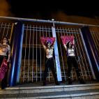 Activists of women's rights organisation Femen, are chained to the gate of Palacio Vistalegre, with the words "against fascist vote" painted on their body, early on October 6, 2019 in Madrid, during a protest against a campaign rally of Spanish ...