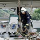 Un bombero trabajando entre los restos del tren