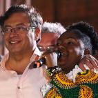 Colombian presidential candidate left-wing Gustavo Petro, listens to his Vice presidential formula Francia Marquez as she delivers a speech during a campaign rally in Cali, Colombia, May 19, 2022. - Petro is leading the polls for the upcoming pr...