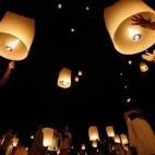 Residentes locales y visitantes encienden y sostienen farolillos durante una ceremonia en recuerdo a las víctimas del tsunami de 2004 en Baan Nam Khem (Tailandia).