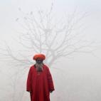 Un sufí pakistaní posa en una calle de Lahore (Pakistán) cubierta por una densa niebla.